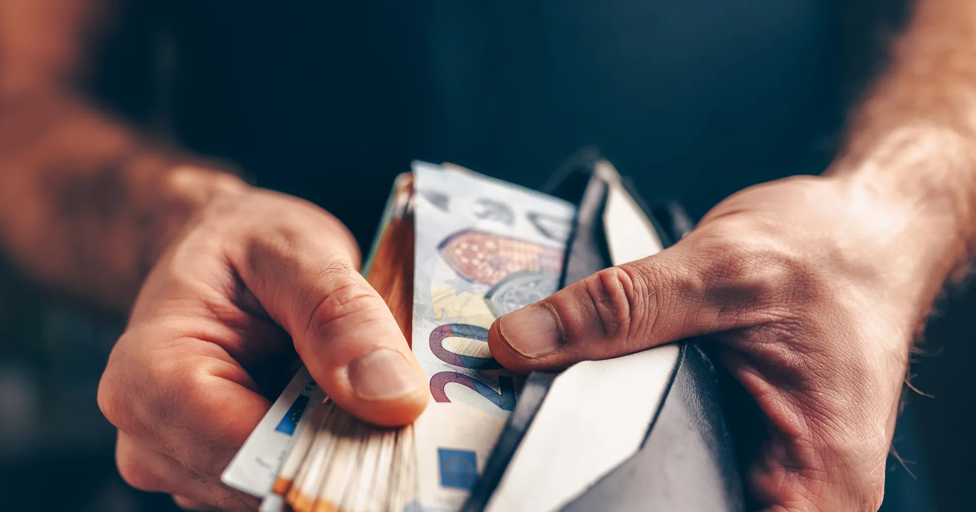 Man met een portemonnee in zijn hand gevuld met geld 